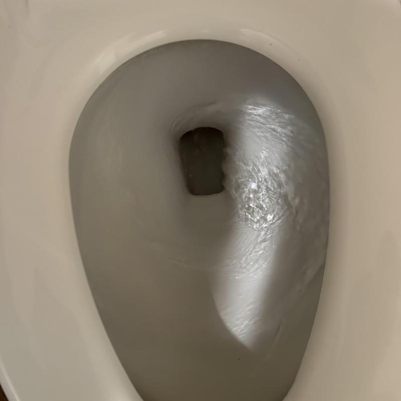 Toilet bowl flushing with clear water flow