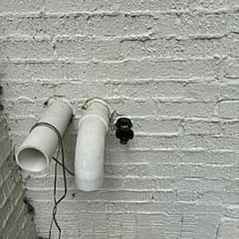 Hose bib with new outdoor plumbing installation on brick wall