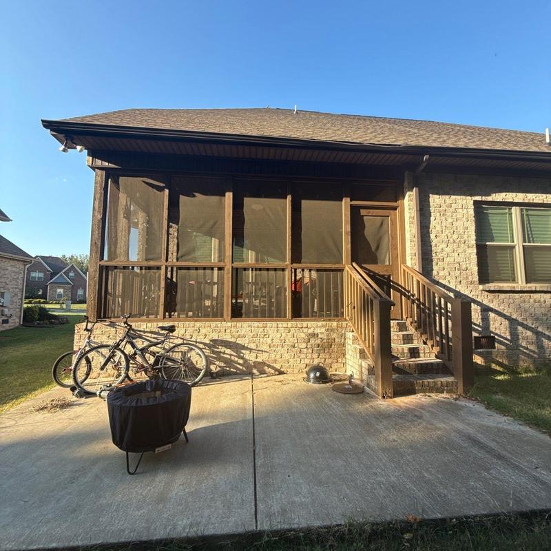 Screened porch exterior with stairs and patio area