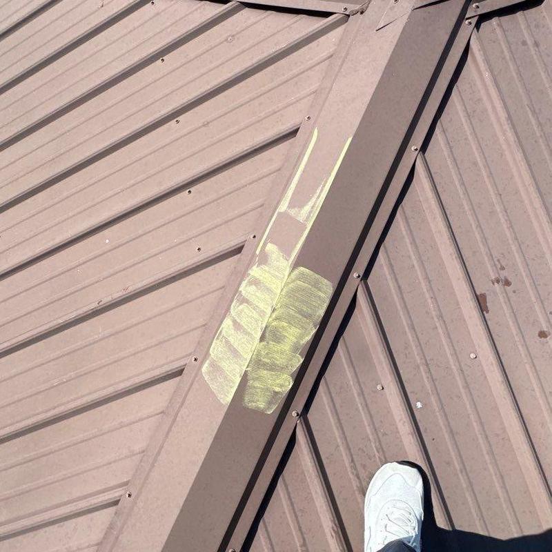 Metal roofing hail damage marked for repair