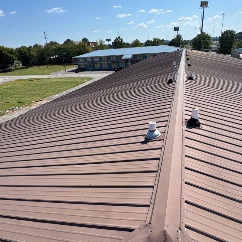 Metal commercial roof with ridge vents and pipe boots