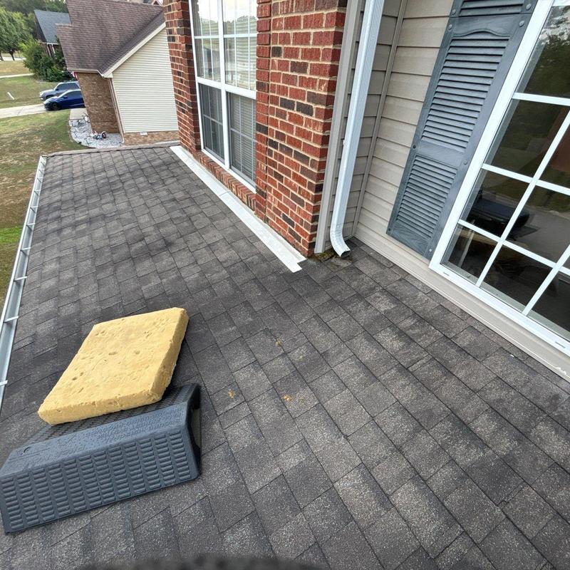 Asphalt shingle roof with hail damage near window and gutter