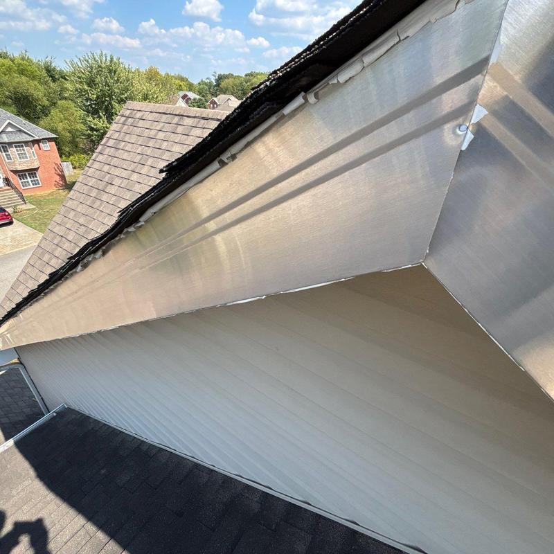 Metal flashing installation along roof edge with shingles