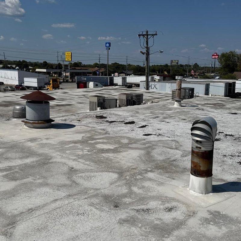 Commercial flat roof surface with hail damage signs