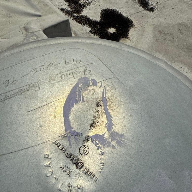 Metal roofing gas vent with hail damage and markings