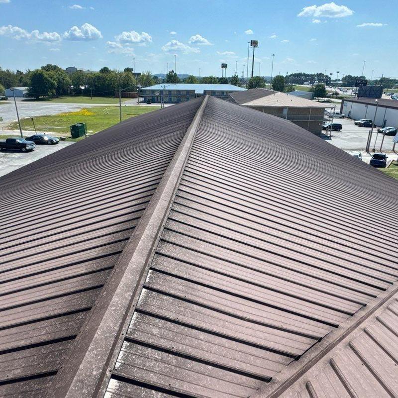 Metal roof panels with hail damage on commercial building