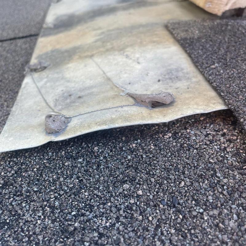 Deteriorated roof flashing with cracked sealant on shingles