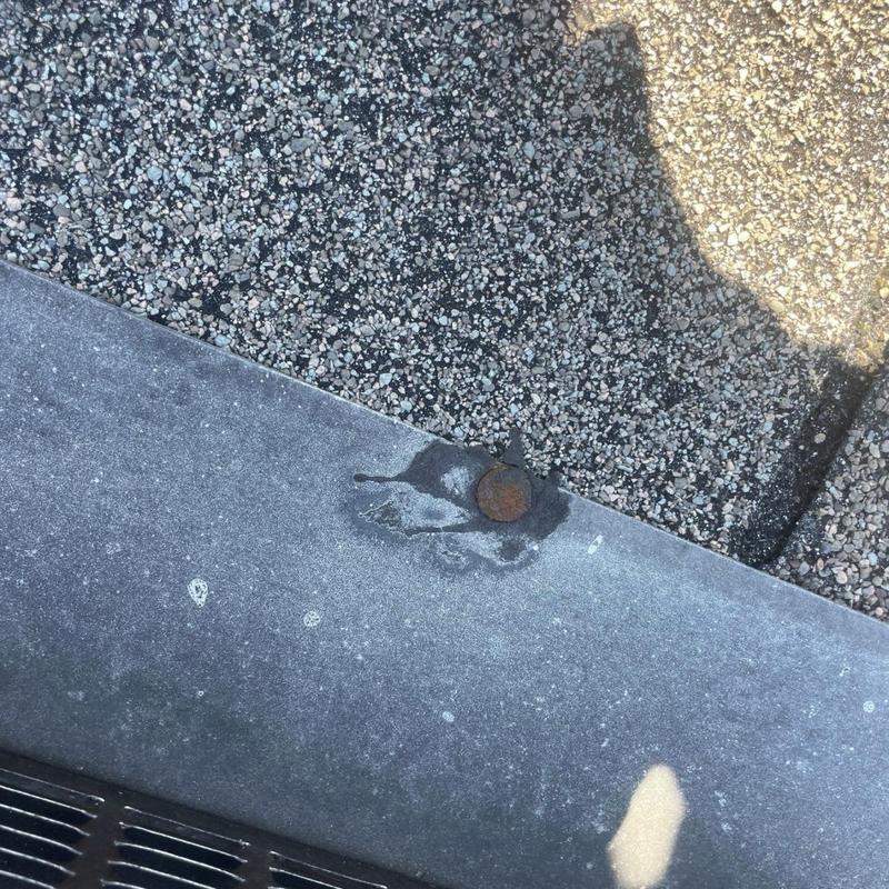 Roof metal flashing with rusted fastener and sealant