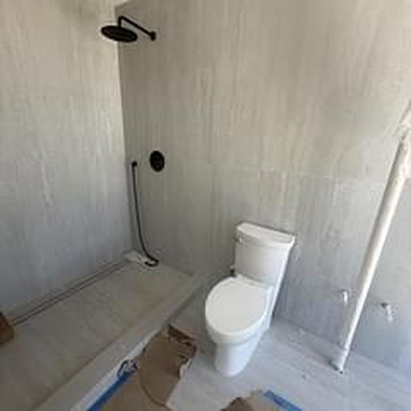 Toilet and shower plumbing fixtures installed in bathroom
