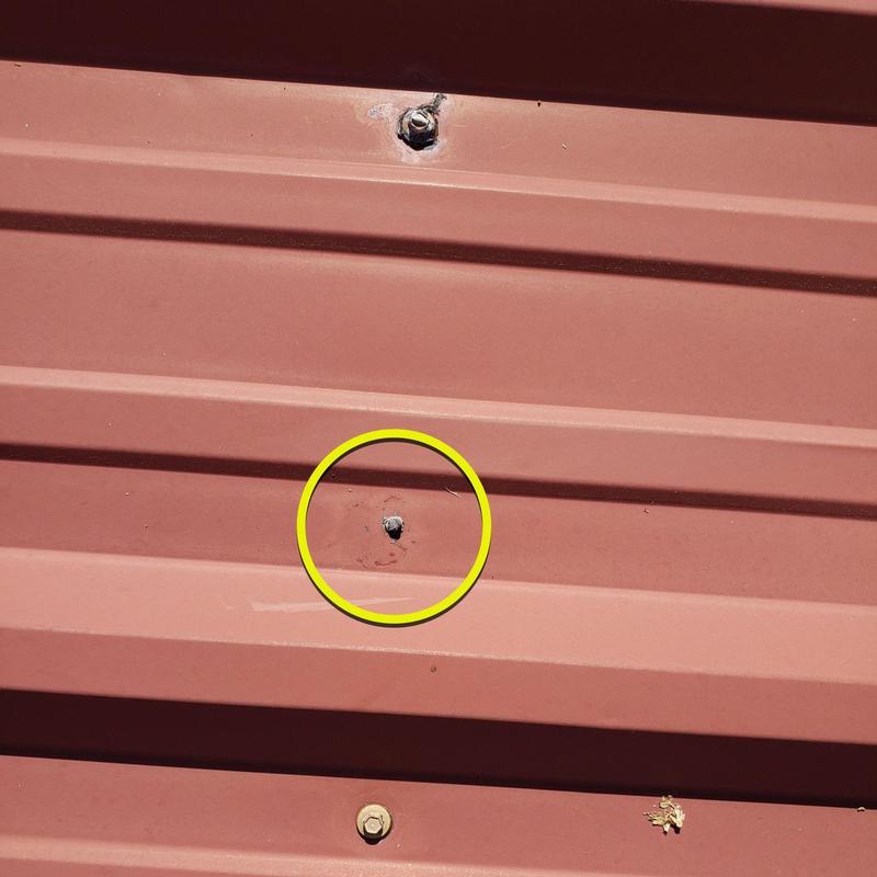 Metal roof loose screw on red panel Metal roof loose screw on red panel