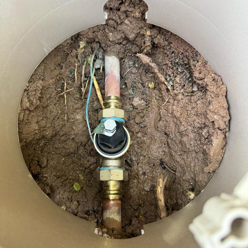 Copper water main with pressure regulator valve in soil