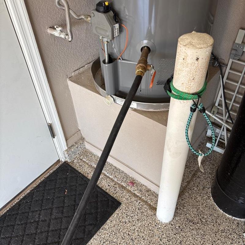 Water heater pilot light with attached hose in garage