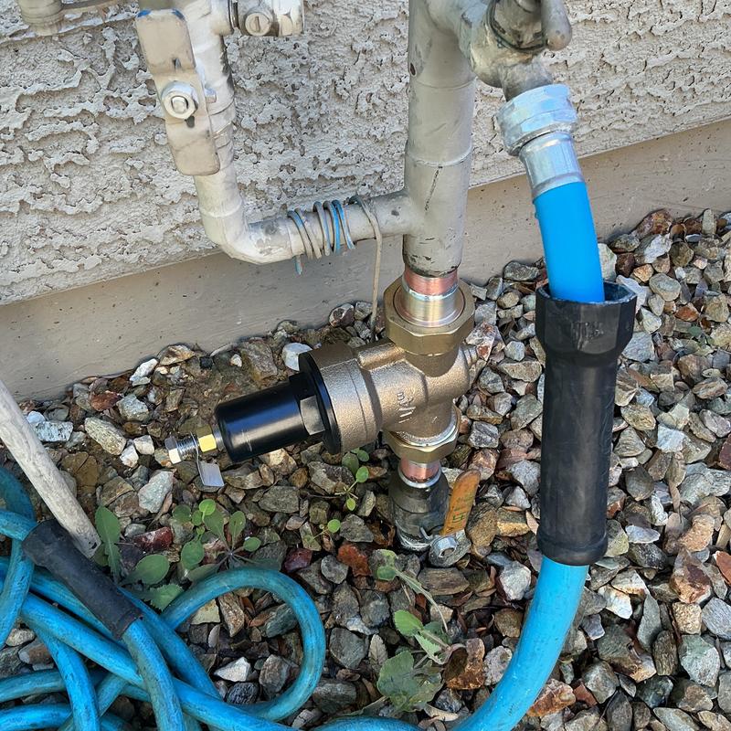 Pressure regulator valve with attached hose outdoors Pressure regulator valve with attached hose outdoors
