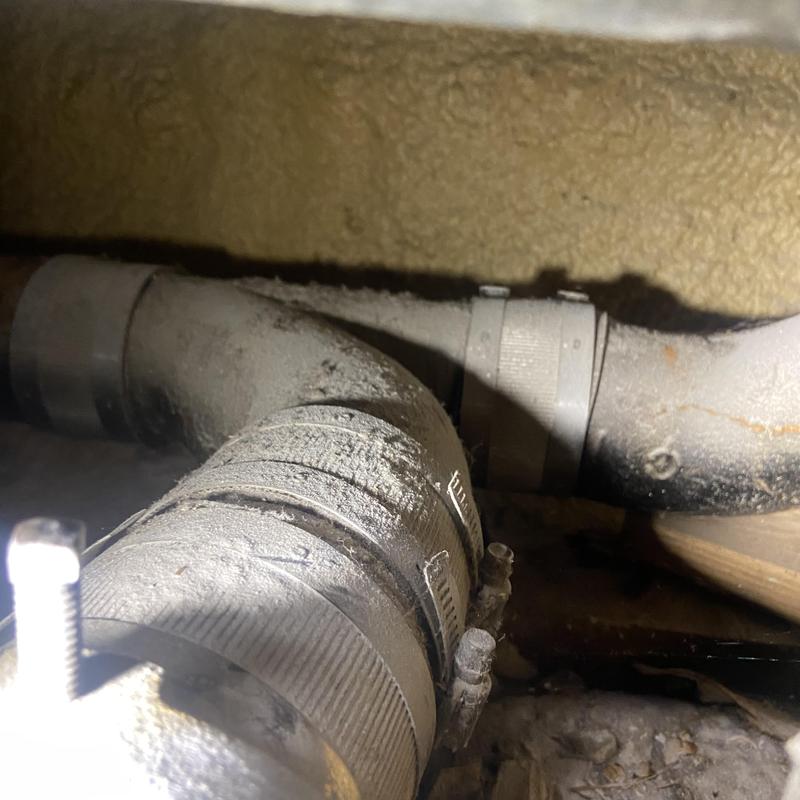 Drain line with corroded cracked PVC piping and clamps