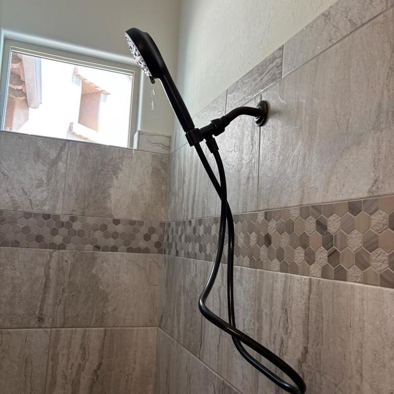 Moen handheld shower head installed in tiled shower
