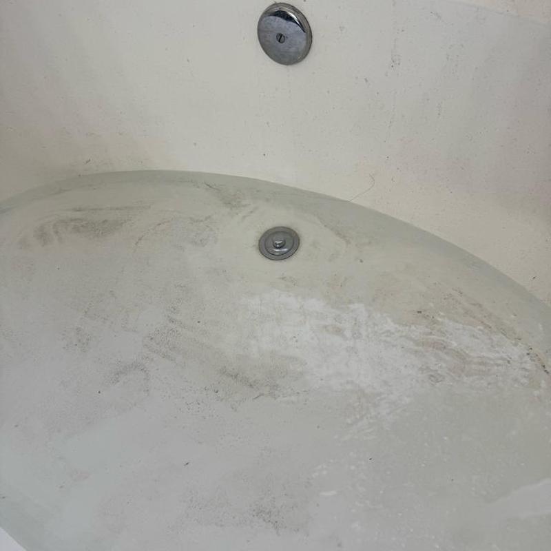 Tub drain with dirt and debris inside tub basin