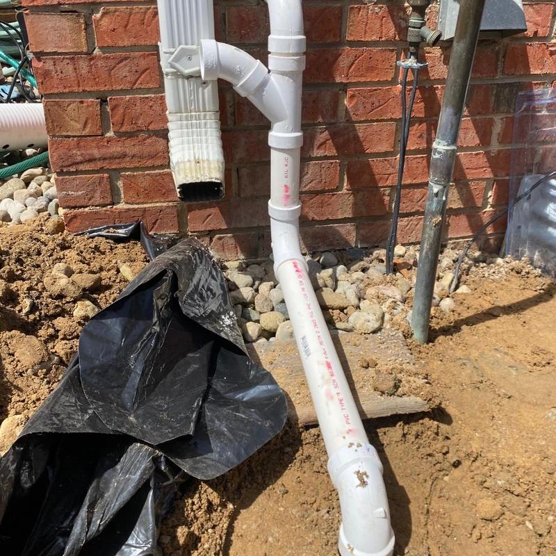 PVC drain system installation by brick wall with gravel