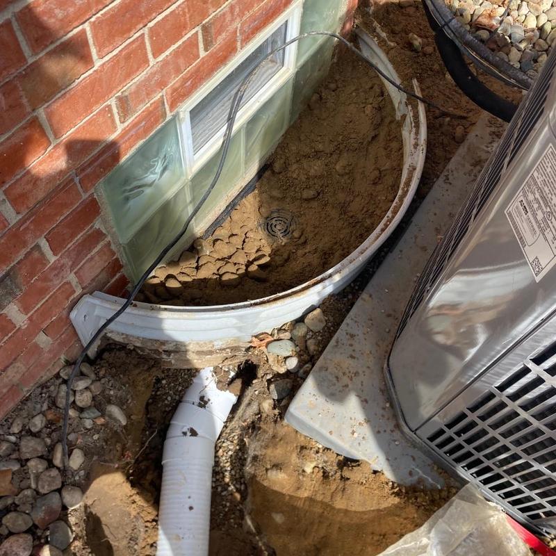 Basement window well drain system installation
