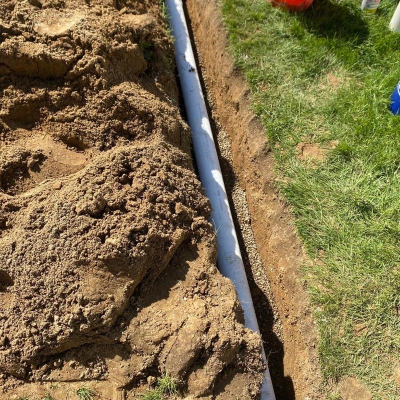 Basement window well drain piping installation