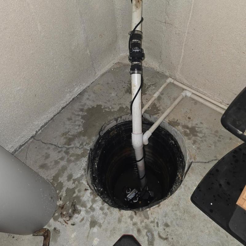Cast iron sump pump with PVC discharge pipe installation