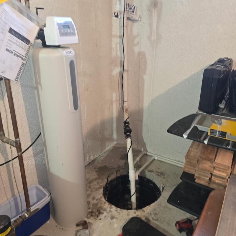 Cast iron sump pump installation in basement corner