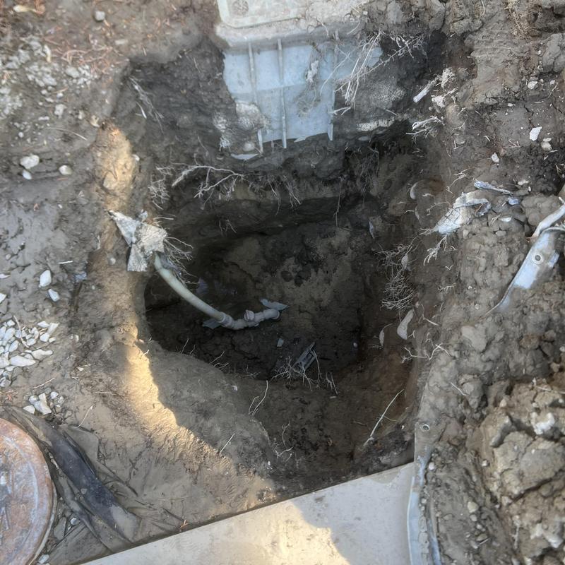 Water main excavation showing exposed piping and valve fittings