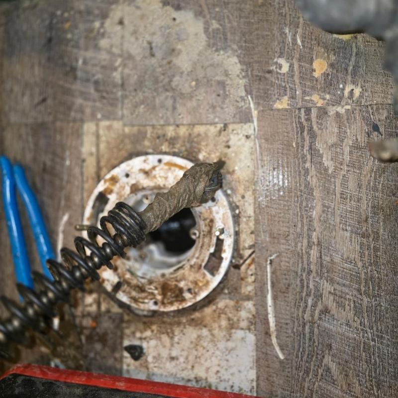 Toilet main line drain snake removing debris