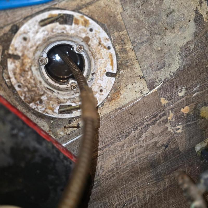 Toilet flange with plumbing auger inside main drain line