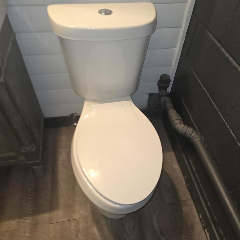 Toilet with adjacent main drain line and pipe connection