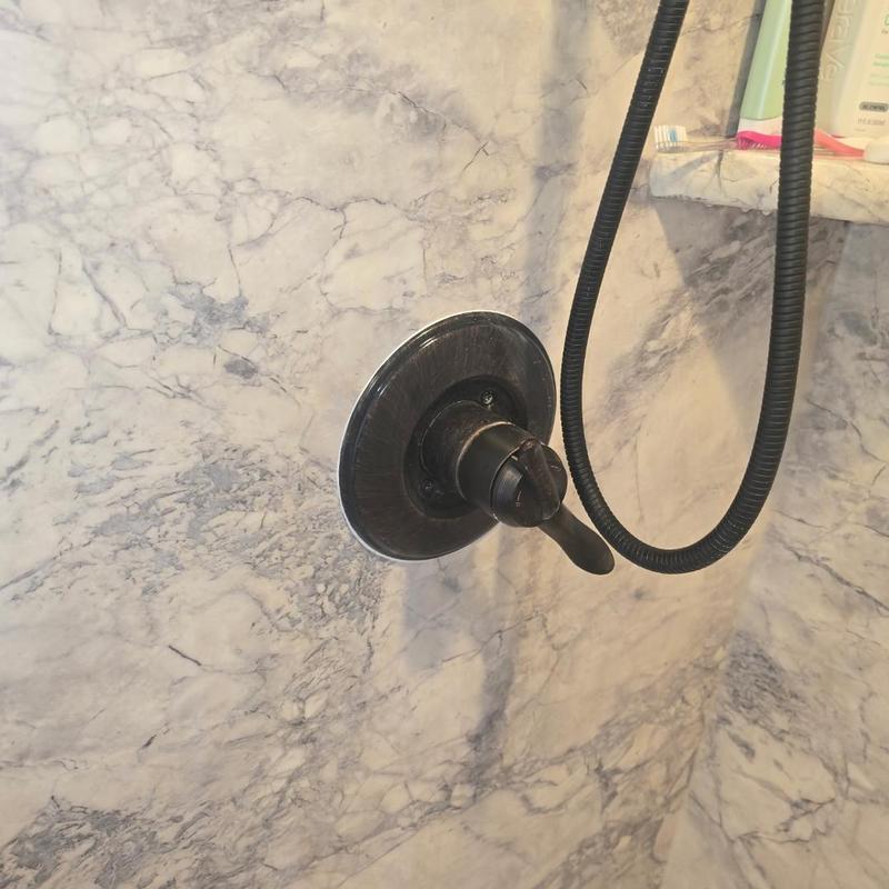 Shower trim plate with caulked sealant and tub spout