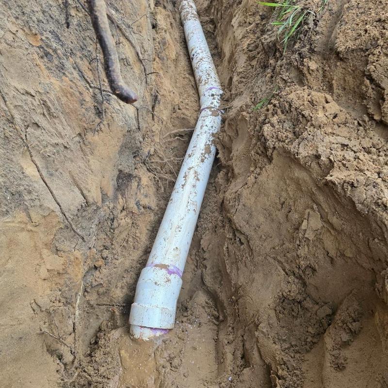 4-inch PVC septic bypass pipe installation in trench