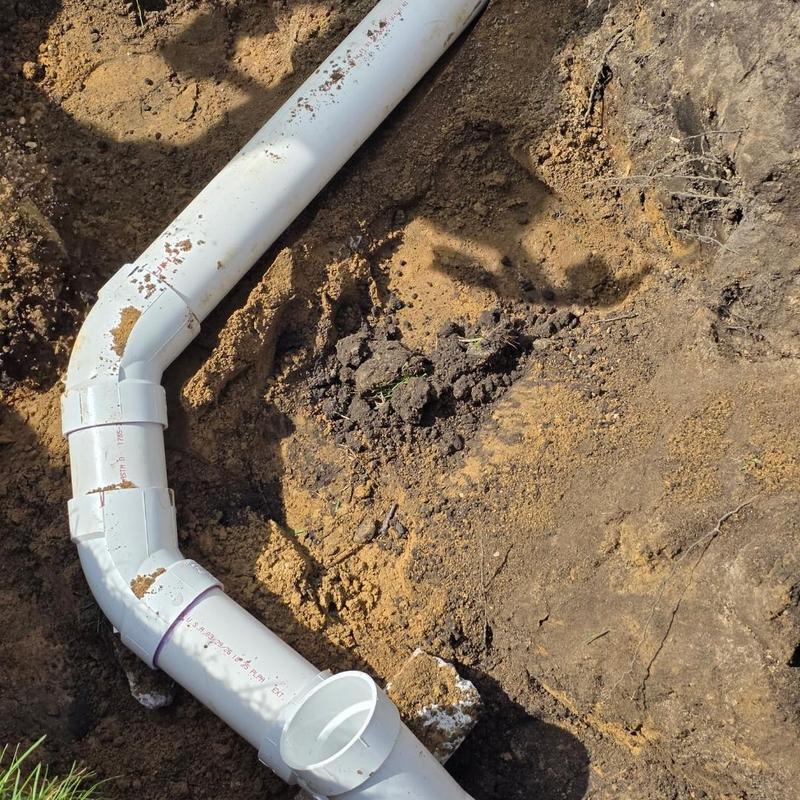 4-inch PVC septic bypass pipe installation in soil trench