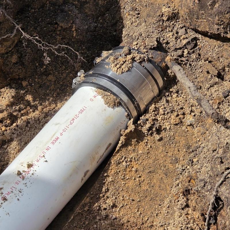 4-inch PVC sewer pipe with coupling in dirt trench