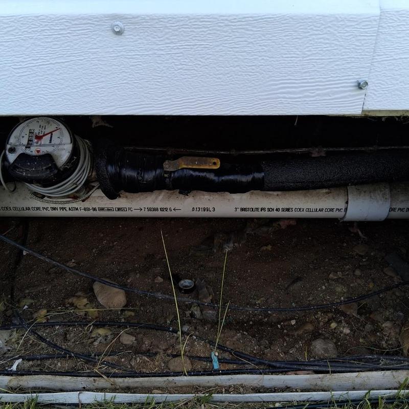 Water meter and copper water line under house exterior wall
