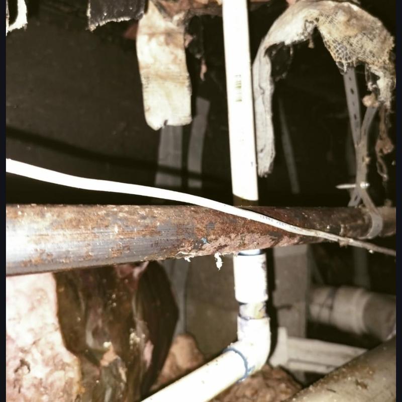 Copper pipe with rust and corrosion in crawl space