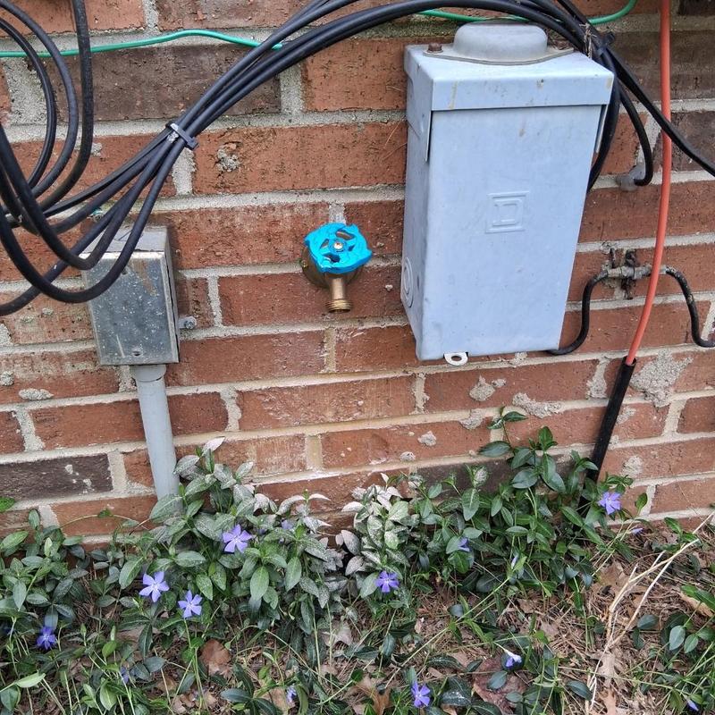 Silcock valve with blue handle installed on brick wall