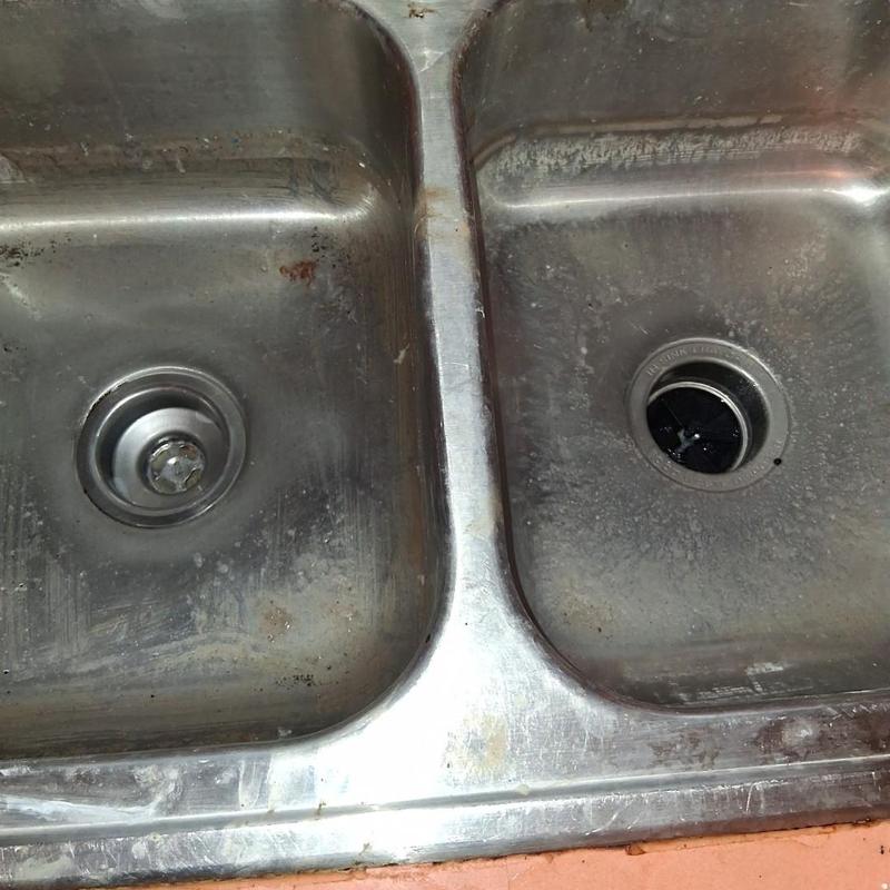Kitchen sink drains with debris and stains