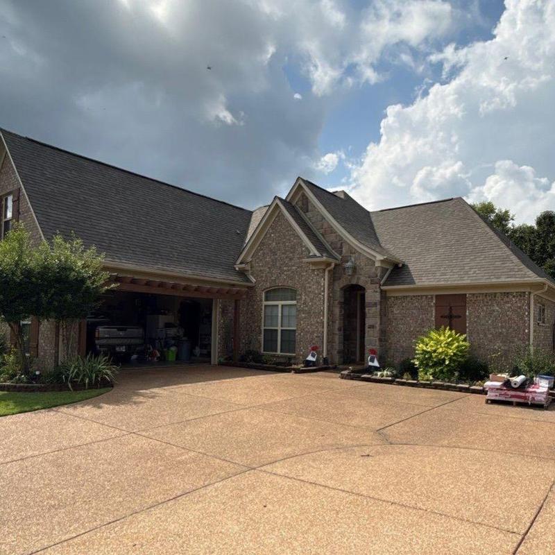 Asphalt shingle roof on suburban brick house with driveway