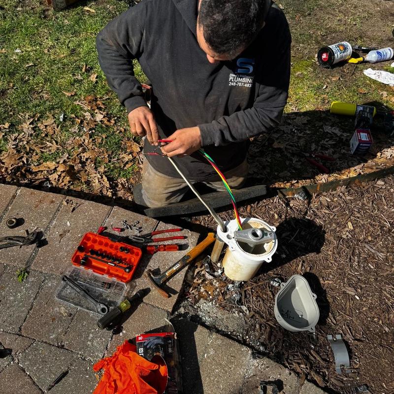 Well pump wiring repair with tools on ground