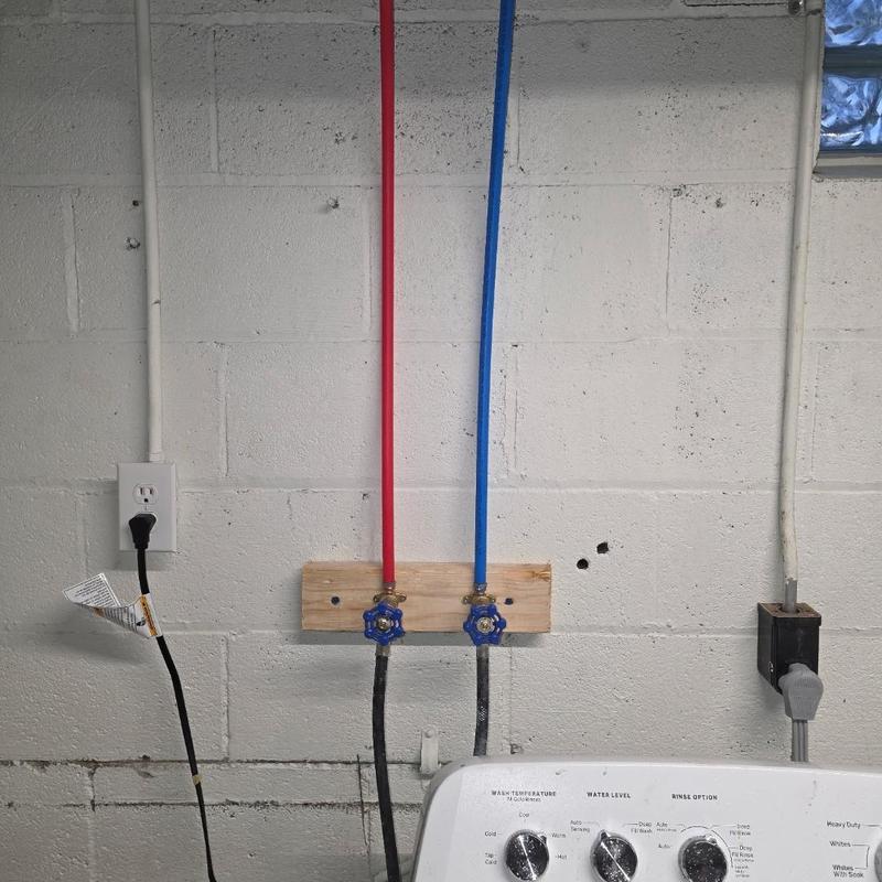 Water supply valves with red and blue pipes in basement