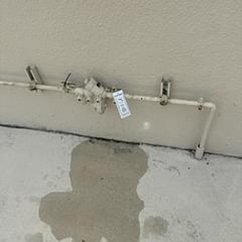 Backflow prevention device mounted on exterior wall