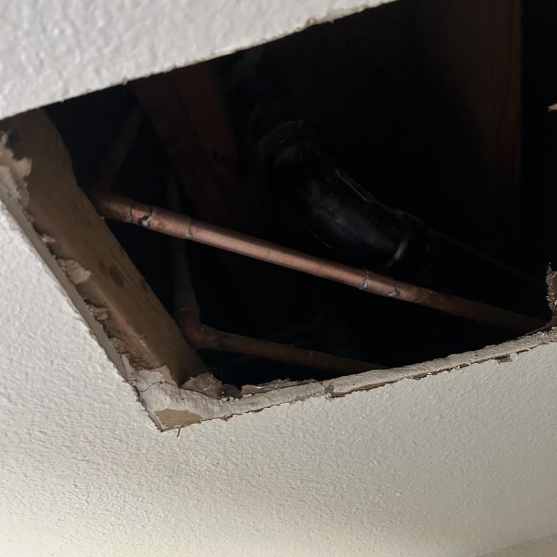 12-inch copper pipe in ceiling with drywall cutout