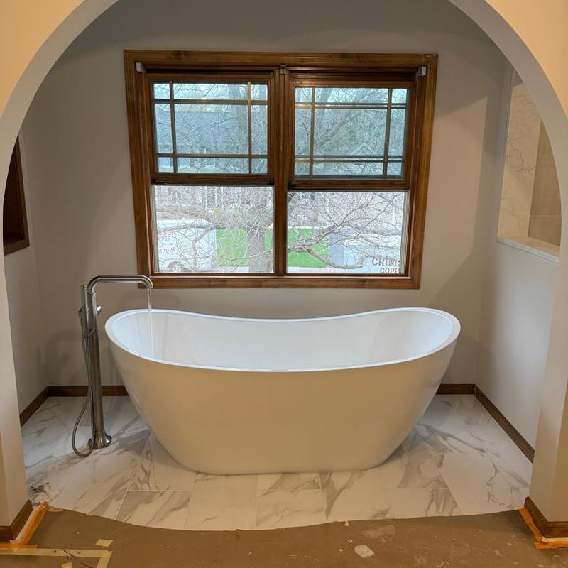 Freestanding bathtub with floor-mounted faucet installation