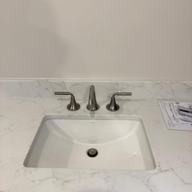 Bathroom sink with brushed nickel faucet and marble countertop