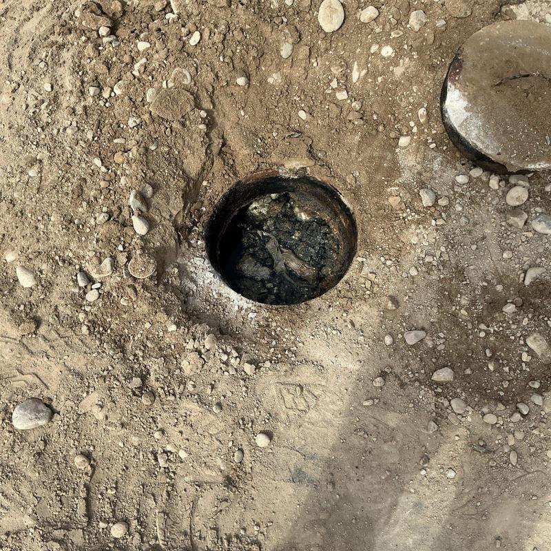 Septic tank inlet pipe excavation with debris inside