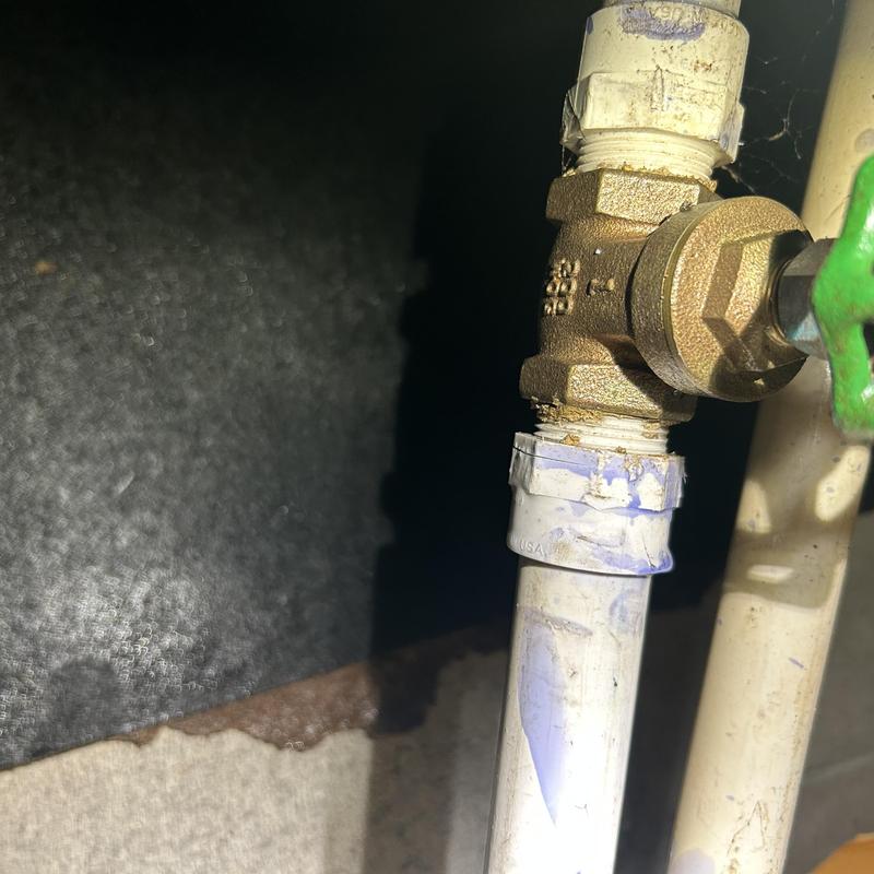 Gate valve with cracked PVC fitting in crawlspace