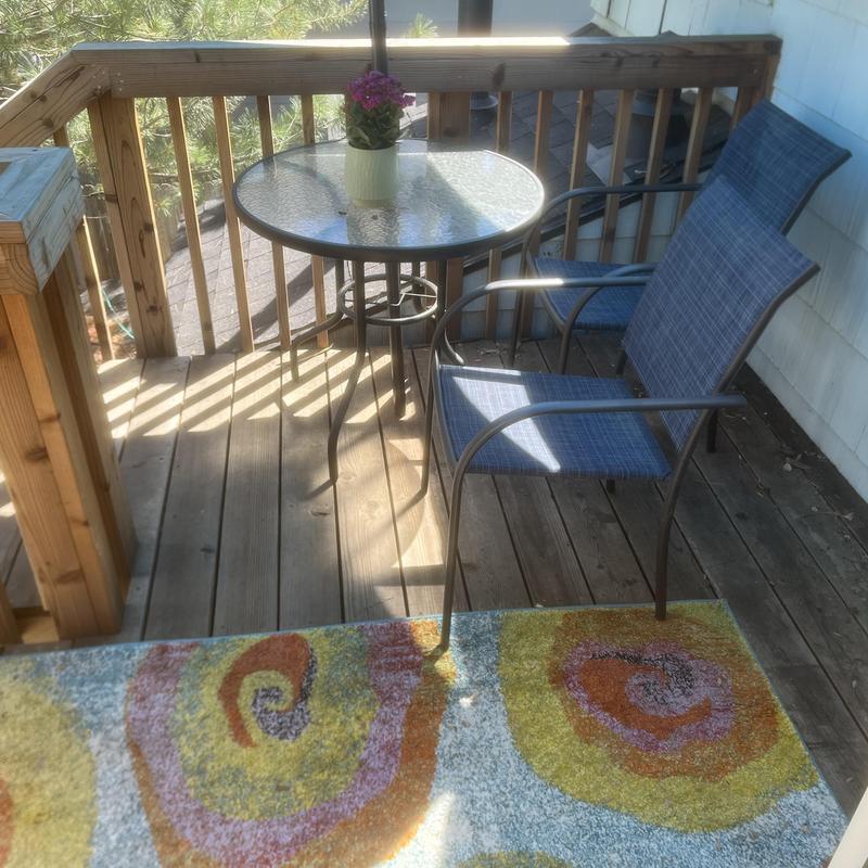 Upstairs deck with wood railing and outdoor furniture