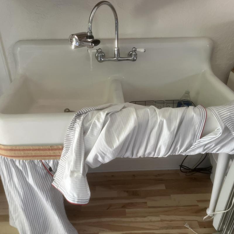 Double basin utility sink with flowing water faucet