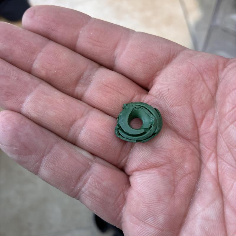 Faucet stem washer held in hand showing wear