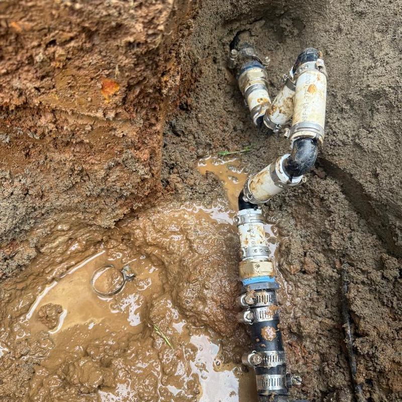 Underground main water line with clamps and fittings in mud
